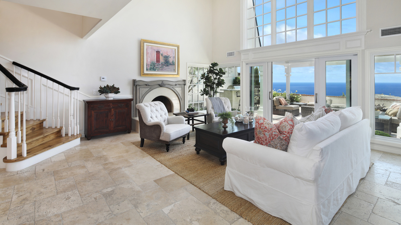 Гостиная комната с высоким потолком и большим окном