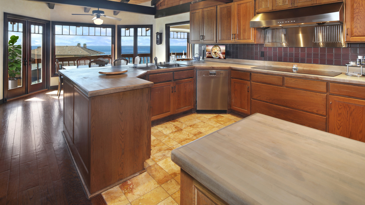 Деревянная мебель на кухне с окнами с видом на море
