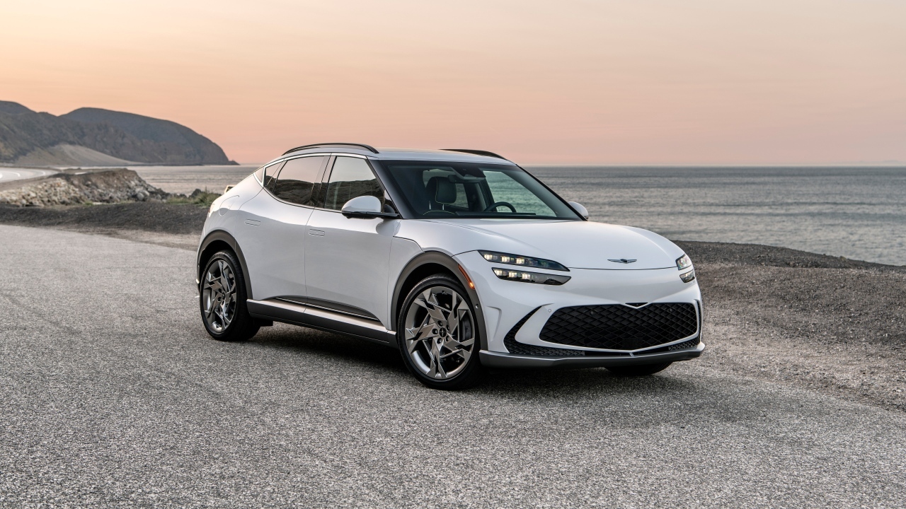 Белый автомобиль Genesis GV60, 2023 года на пляже