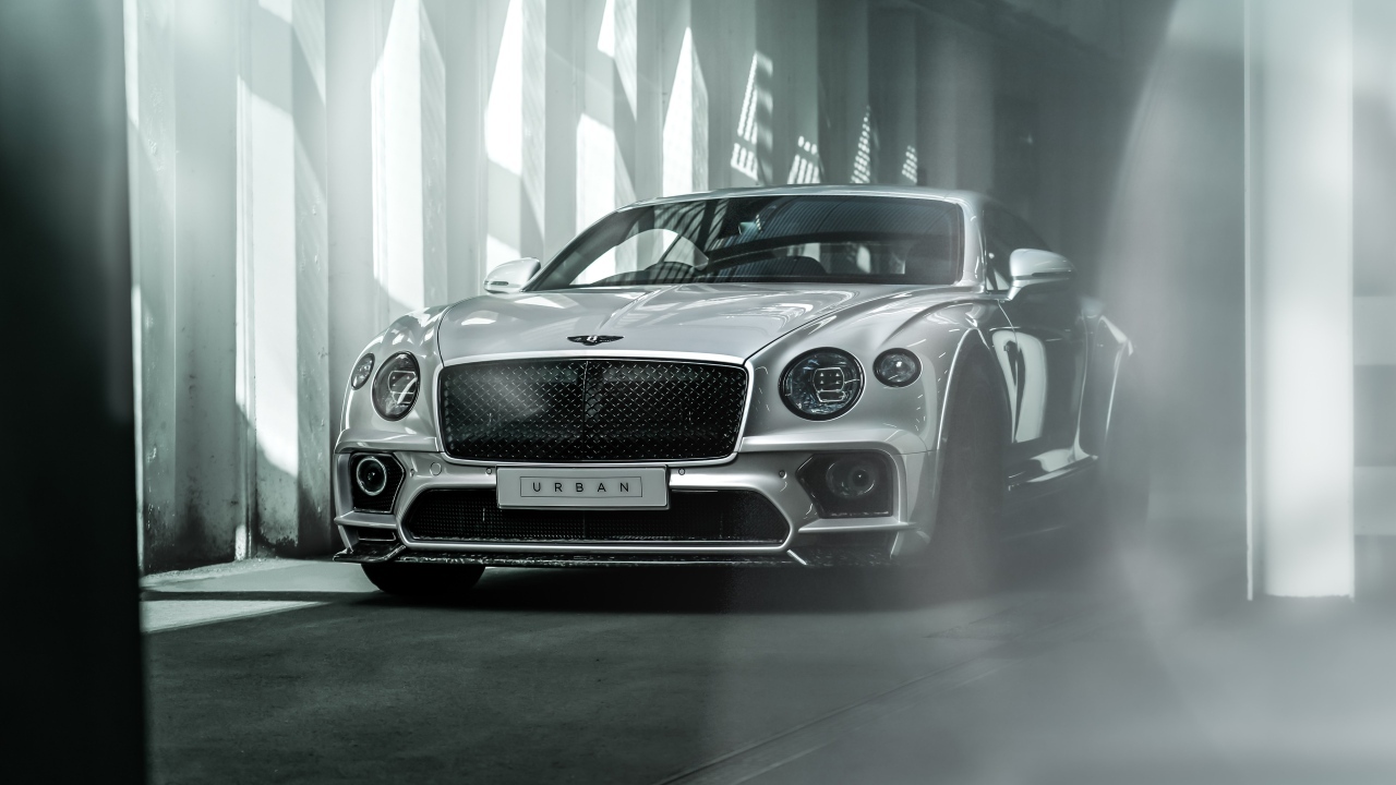 Серебристый автомобиль Bentley Continental GT в здании