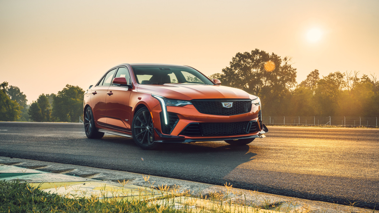 Красный Cadillac CT4-V на дороге на фоне солнца 