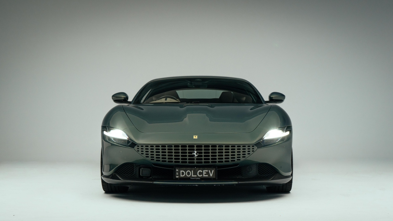 Автомобиль Ferrari Roma на сером фоне вид спереди