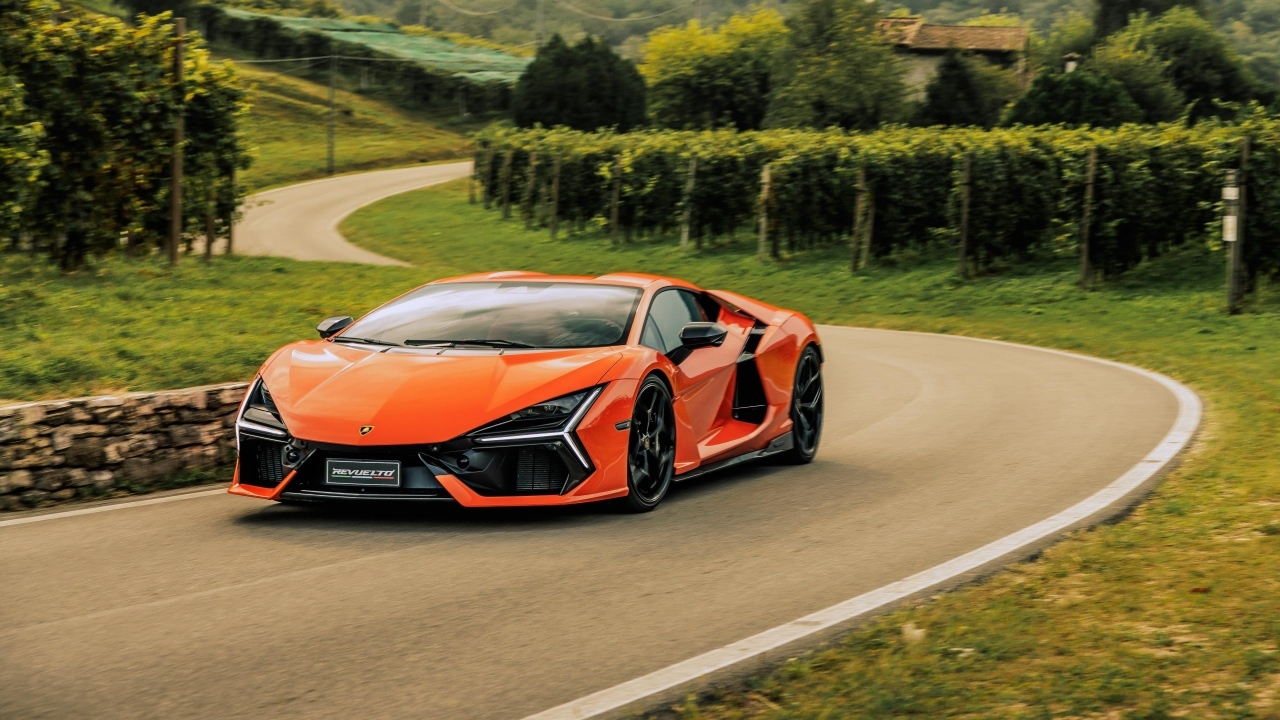 Оранжевый автомобиль Lamborghini Revuelto на дороге