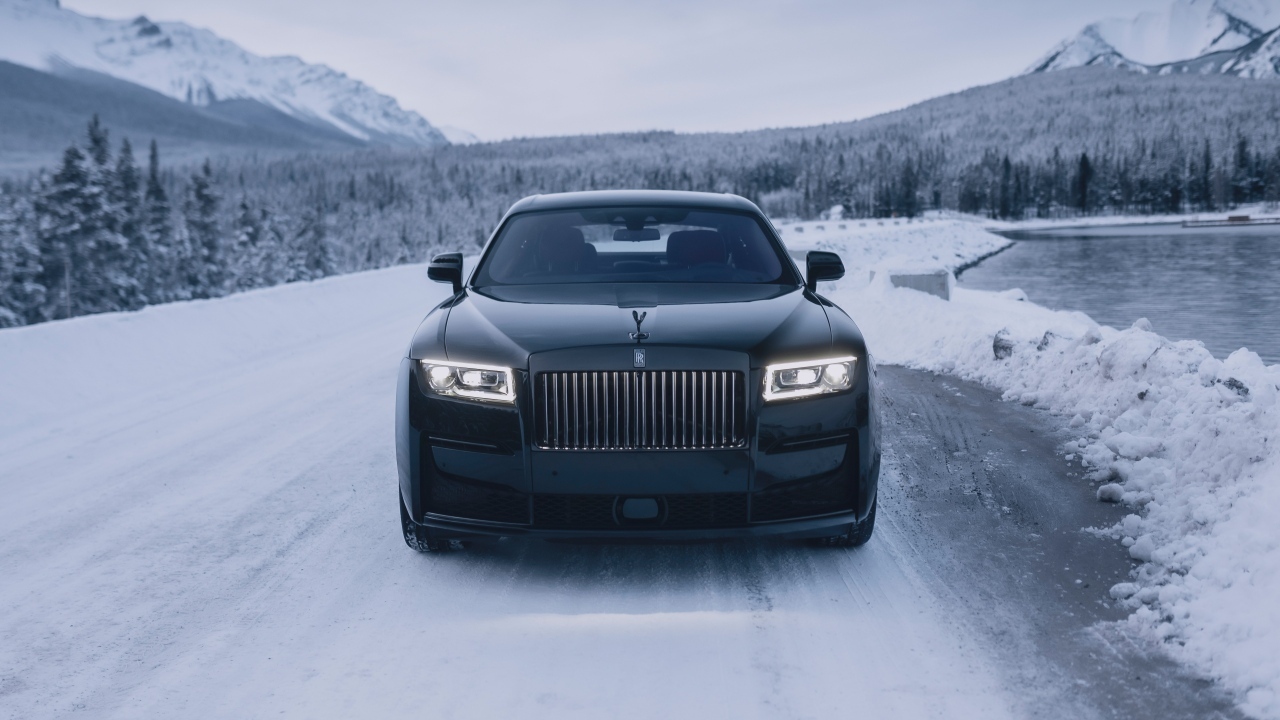 Черный автомобиль Rolls-Royce Black Badge Ghost  на зимней дороге