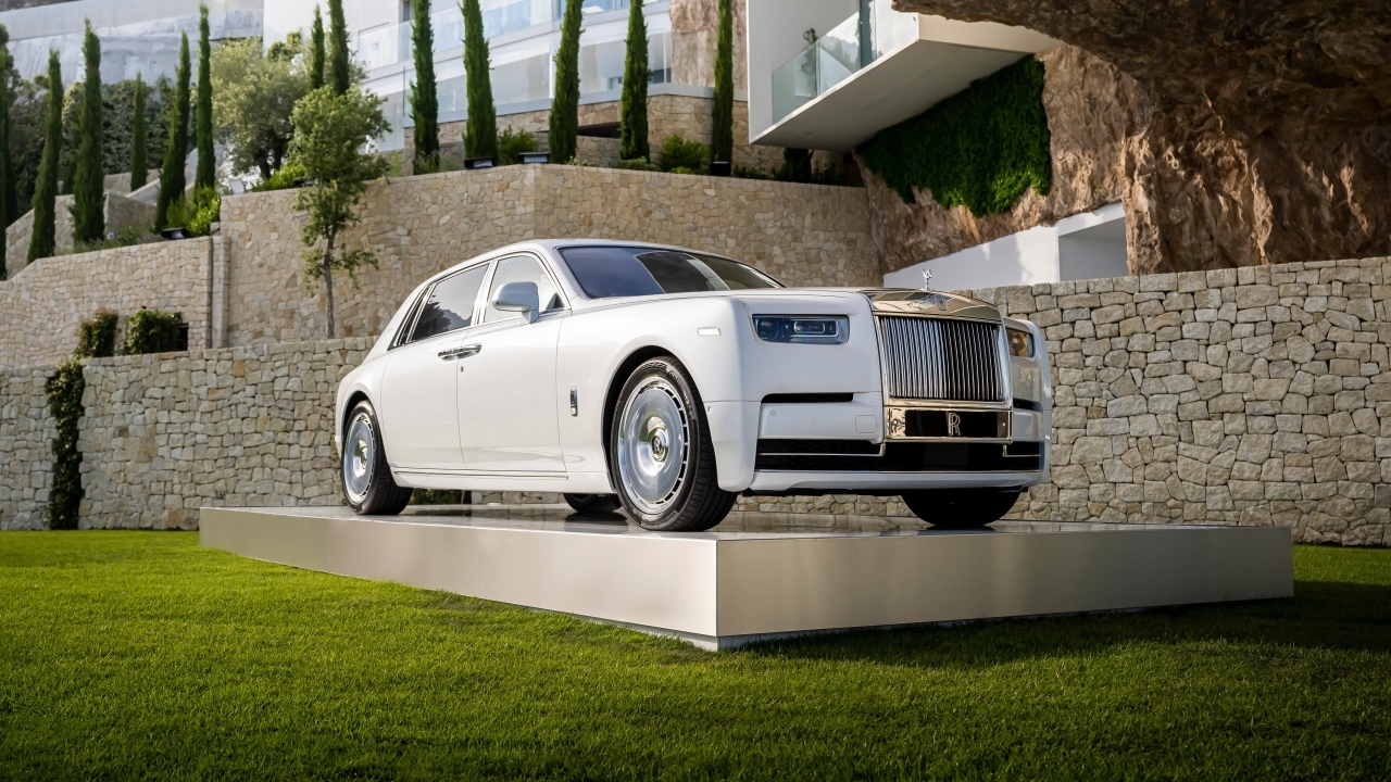 Белый автомобиль Rolls-Royce Phantom 2022 года у дома
