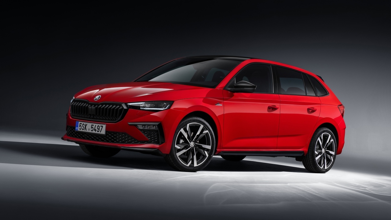 Красный автомобиль Skoda Scala Monte Carlo 2023 года на сером фоне