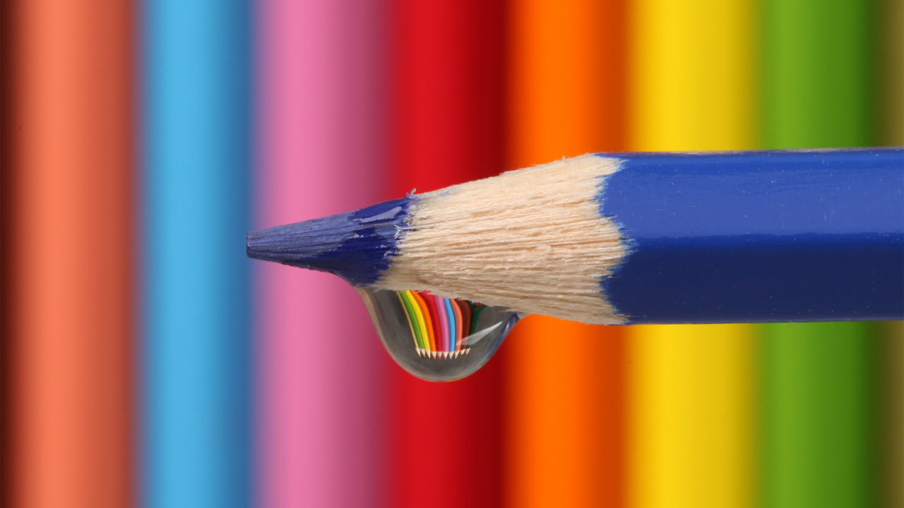 Капля воды стекает с синего карандаша