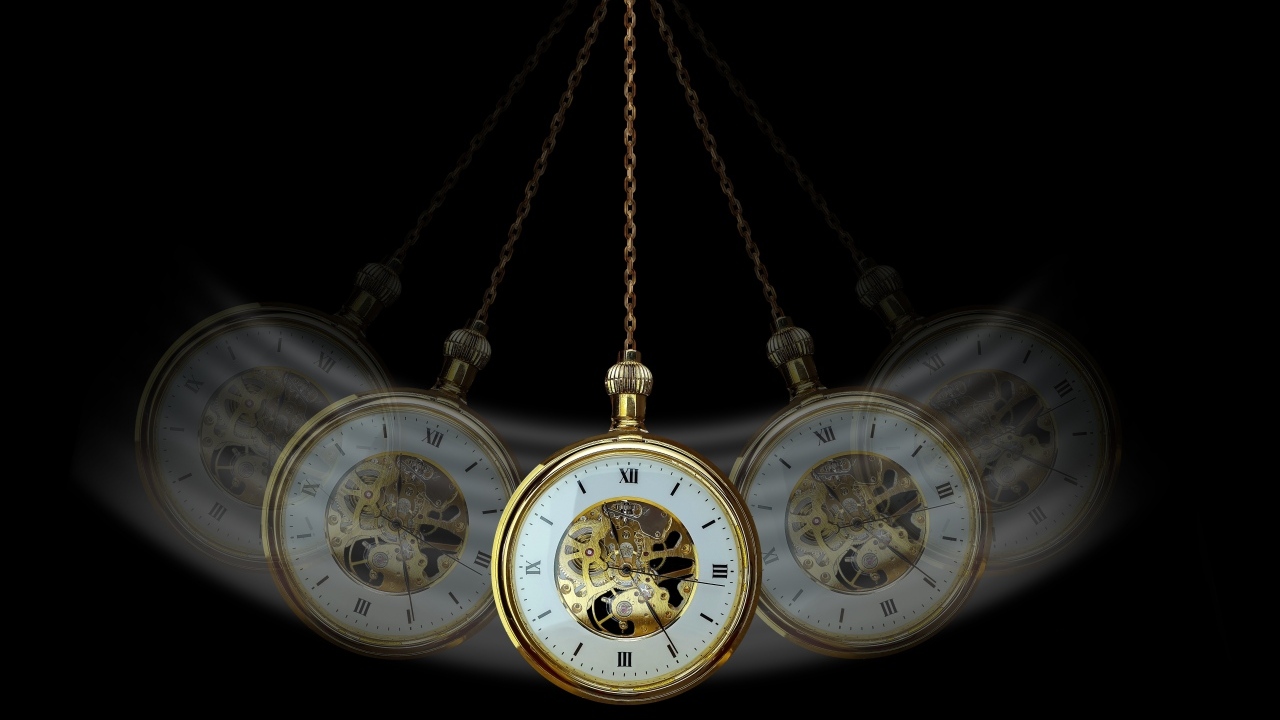 Карманные часы раскачиваются на черном фоне