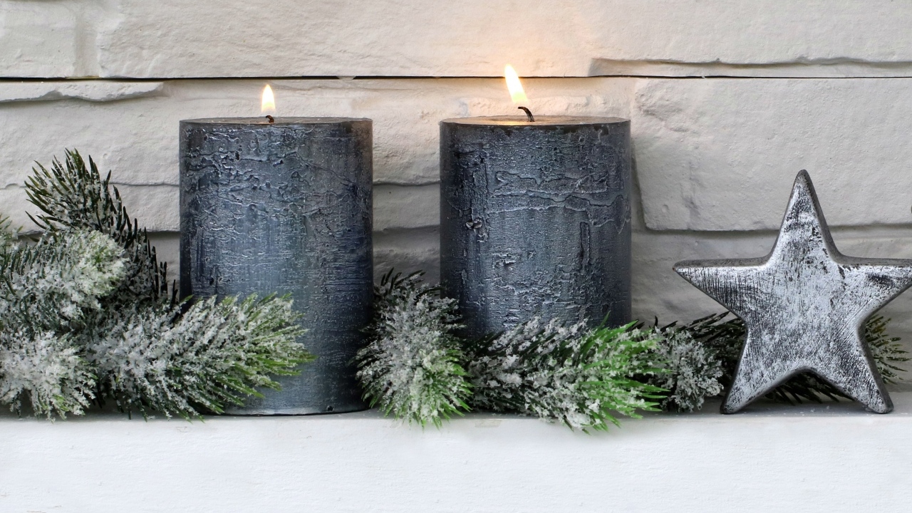 Две большие зажженные свечи у стены