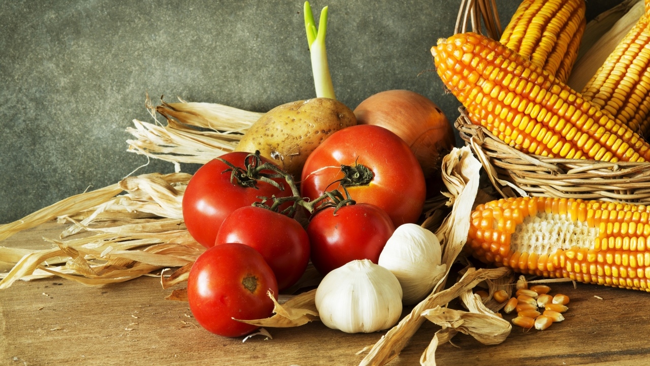 Кукуруза, чеснок и помидоры на столе
