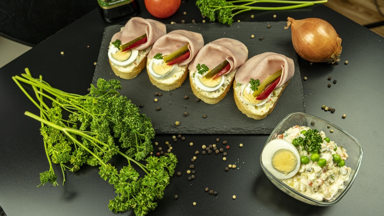 Вкусные бутерброды с ветчиной на столе с петрушкой