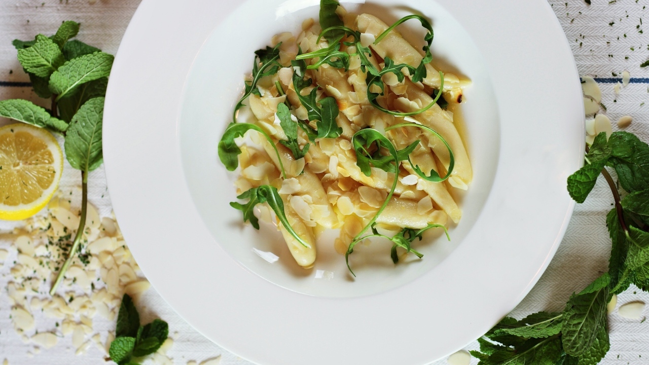 Блюдо с листьями рукколы в большой белой тарелке