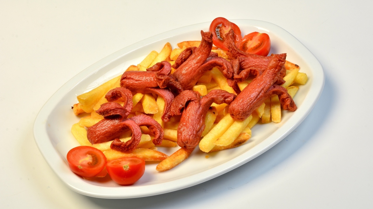Картофель фри на тарелке с помидорами и сосисками