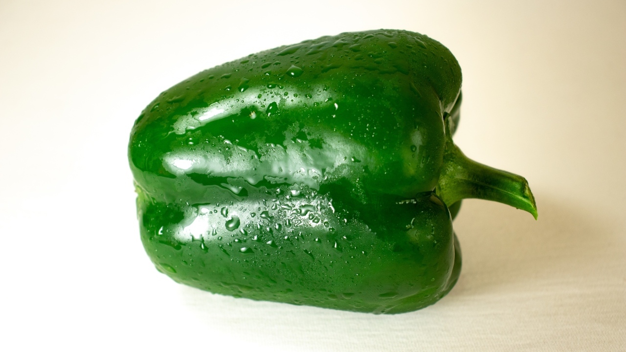 Крупный зеленый перец на белом фоне