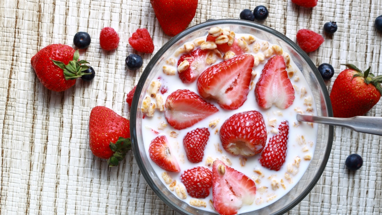 Овсянка с молоком в тарелке с ягодами малины