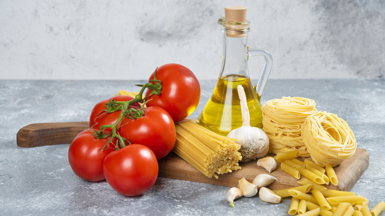 Паста, помидоры и масло на столе
