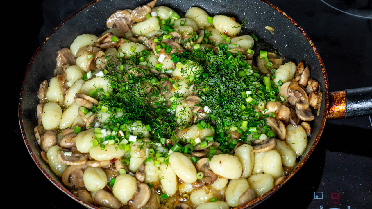 Картофель с шампиньонами и зеленым луков в сковороде