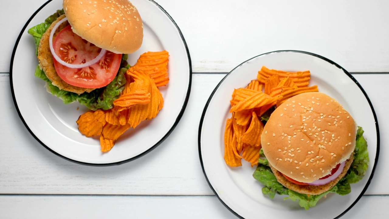 Два гамбургера на тарелке с чипсами