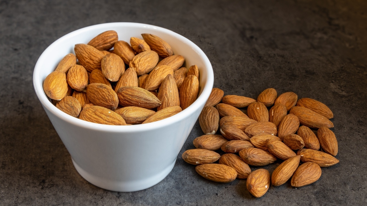 Миндальные орехи в белой пиале на столе