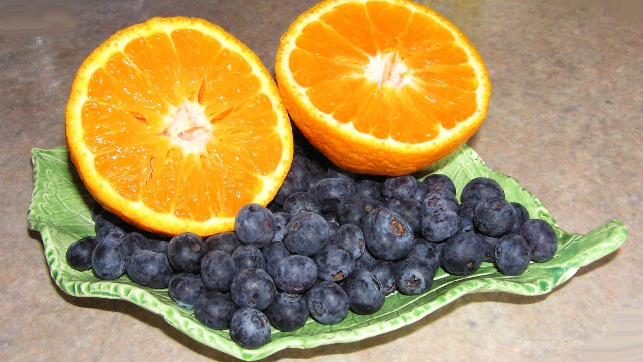 Половинки апельсина с ягодами черники на столе
