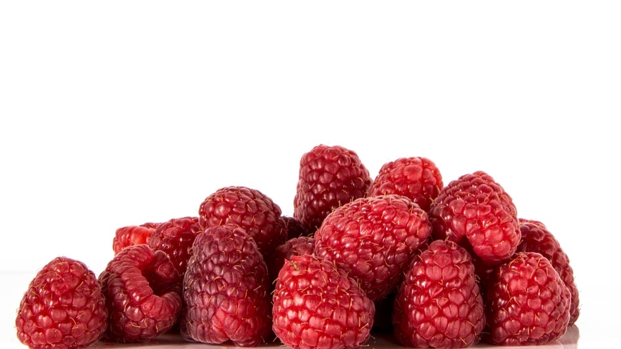 Спелые красные ягоды малины на белом фоне