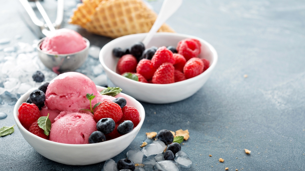 Сладкие ягоды с шариками мороженого на столе