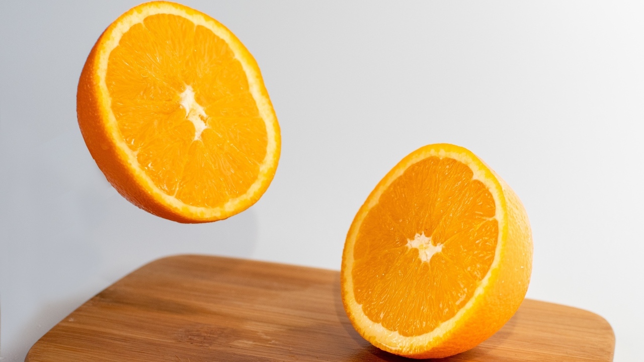 Две половинки апельсина на деревянной доске