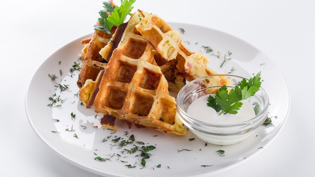 Вафли с соусом и зеленью на тарелке