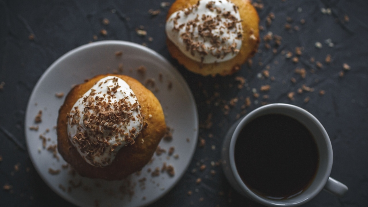 Пирожное в тертым шоколадом на столе с чашкой кофе