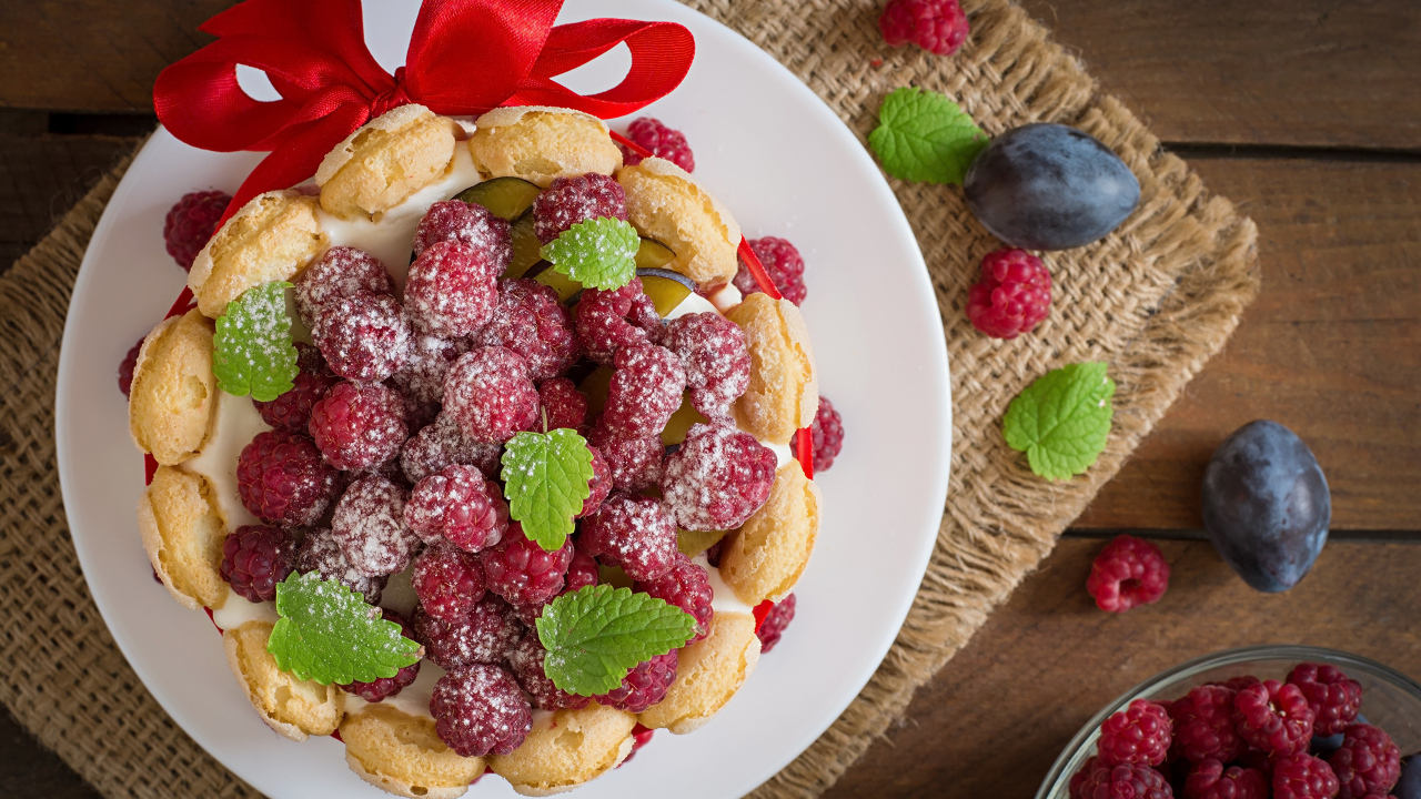 Пирожное с кремом и ягодами малины с ленточкой