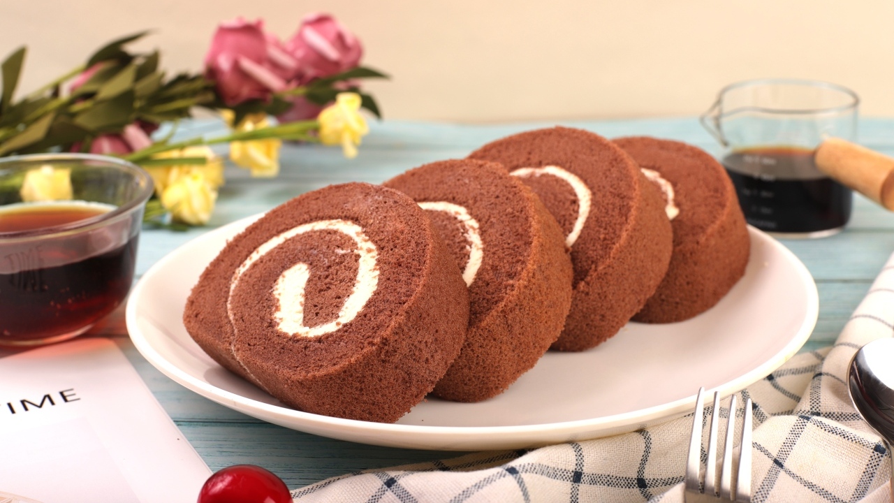 Шоколадный бисквитный рулет с кремом на тарелке