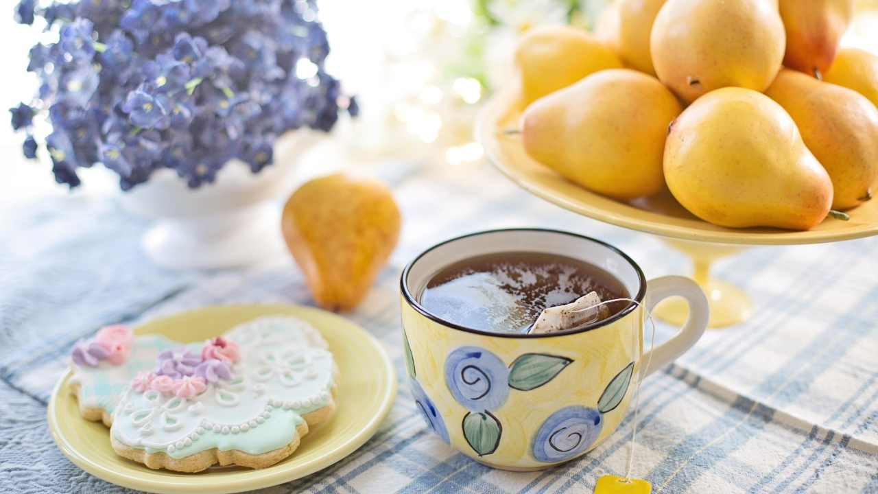 Чашка чая на столе с грушами и печеньем