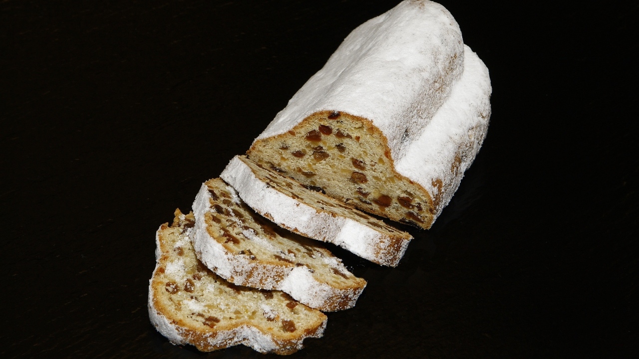 Кекс с изюмом и сахарной пудрой на черном фоне