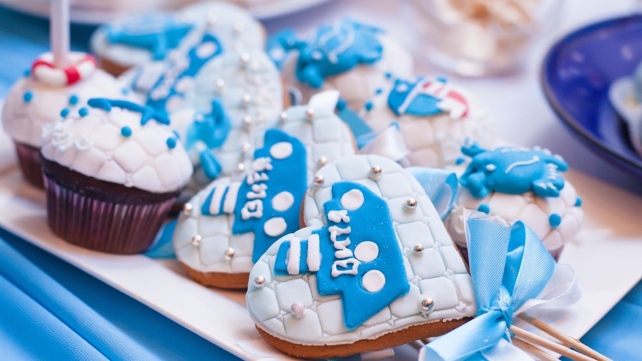 Пряники в форме сердца на палочке с кексами на столе