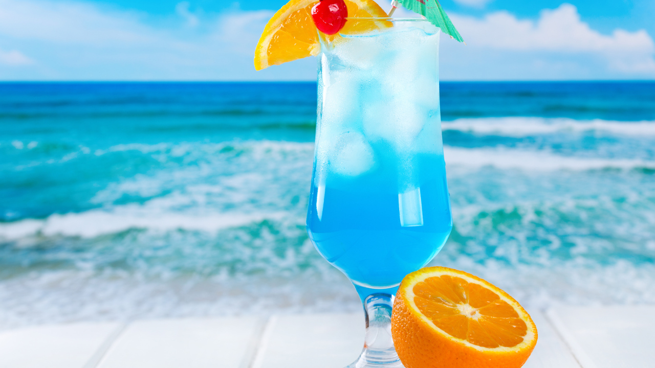 Голубой коктейль со льдом и половинкой апельсина