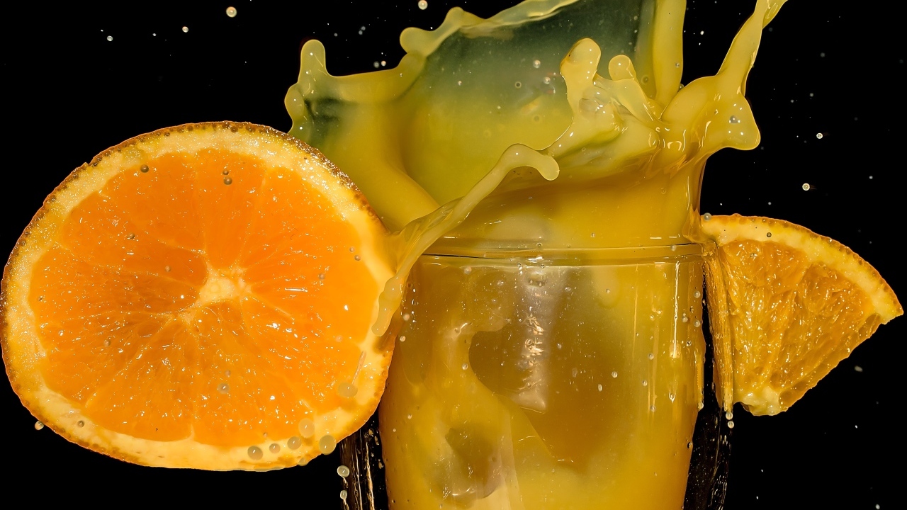 Свежий апельсиновый сок на черном фоне