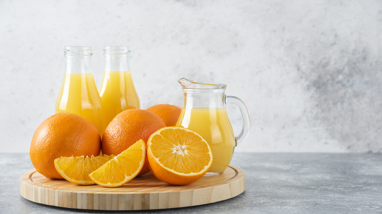 Свежевыжатый сок на столе с апельсинами
