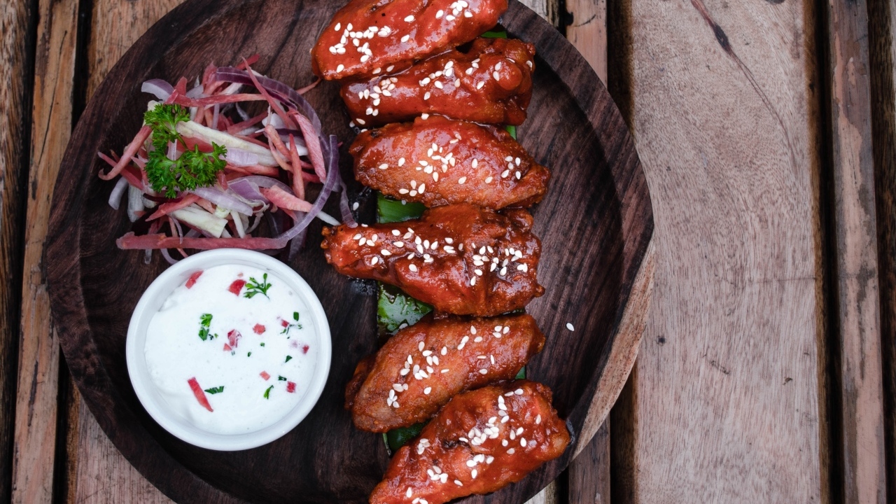 Запеченные куриные крылышки с соусом на тарелке