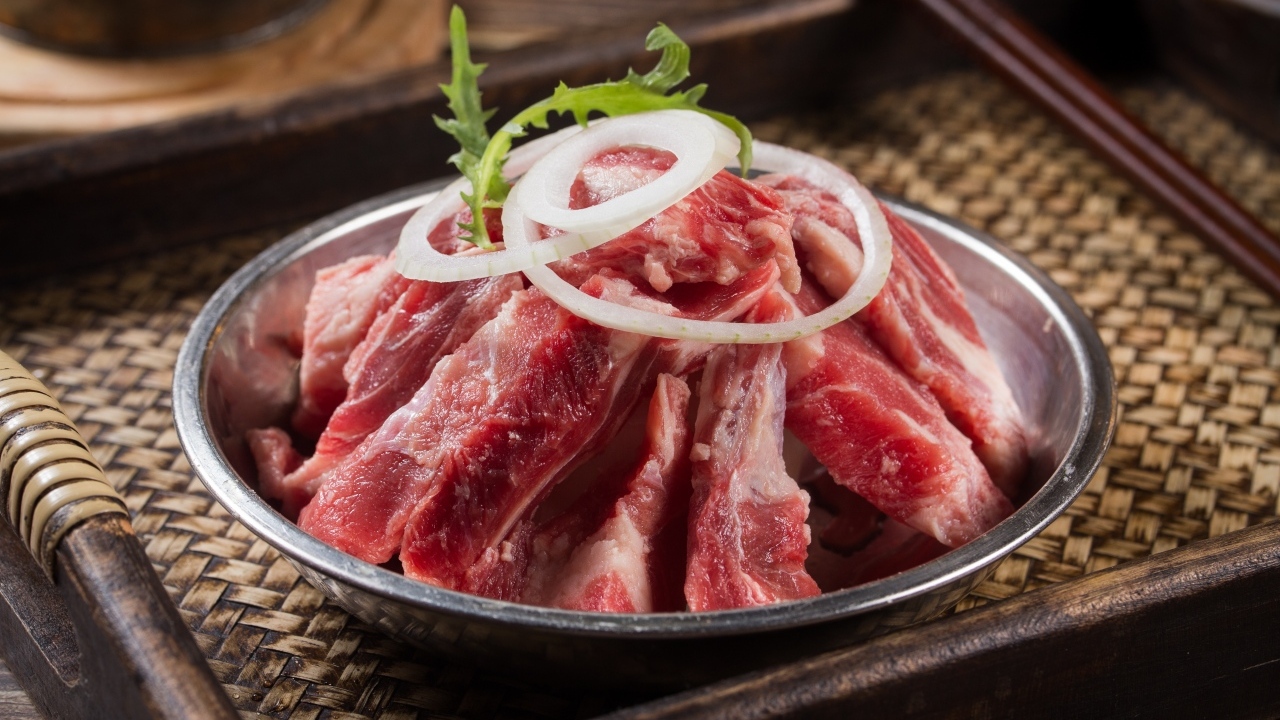 Свежие свиные ребра с луком в миске