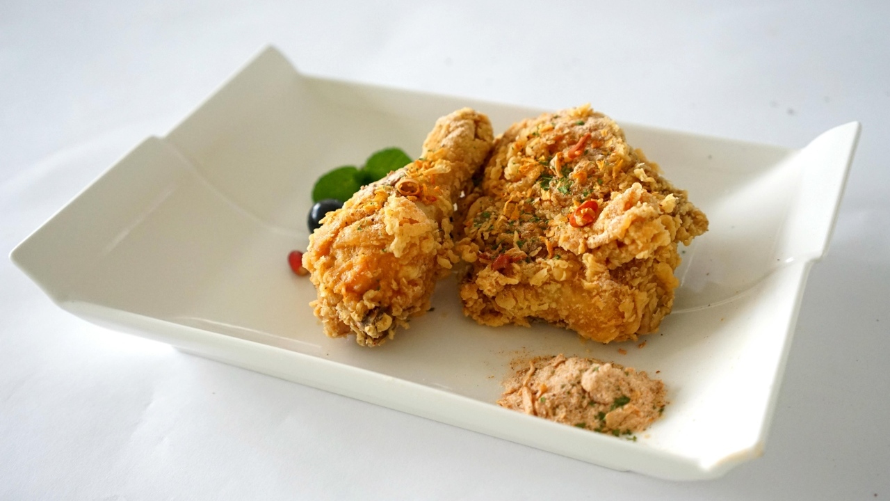 Жареная хрустящая курица в тарелке на столе