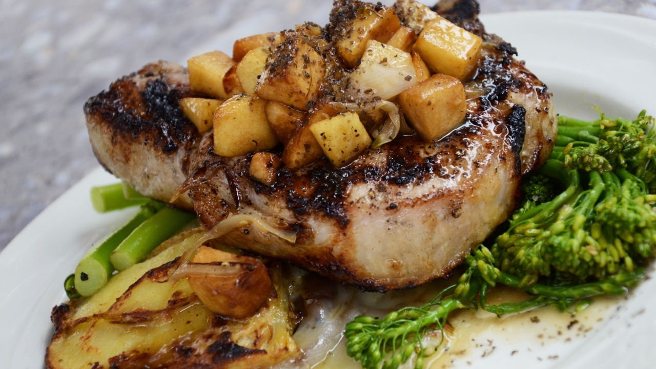 Кусок запеченного мяса на тарелке с овощами