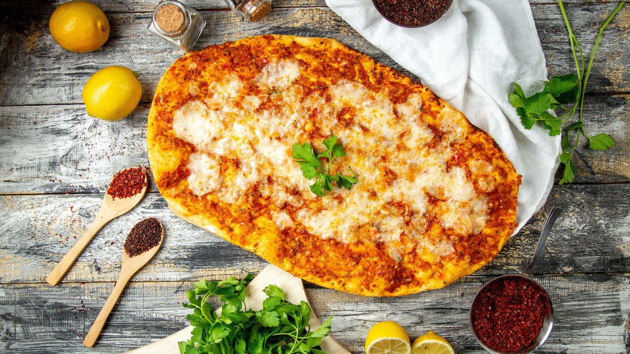 Пицца на столе с лимонами и пряностями