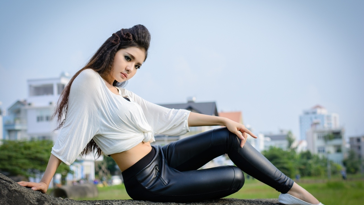 Девушка азиатка в черных кожаных брюках