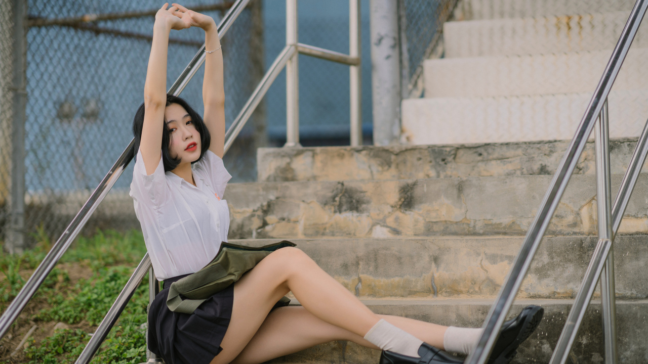 Девушка азиатка потягивается на ступеньках
