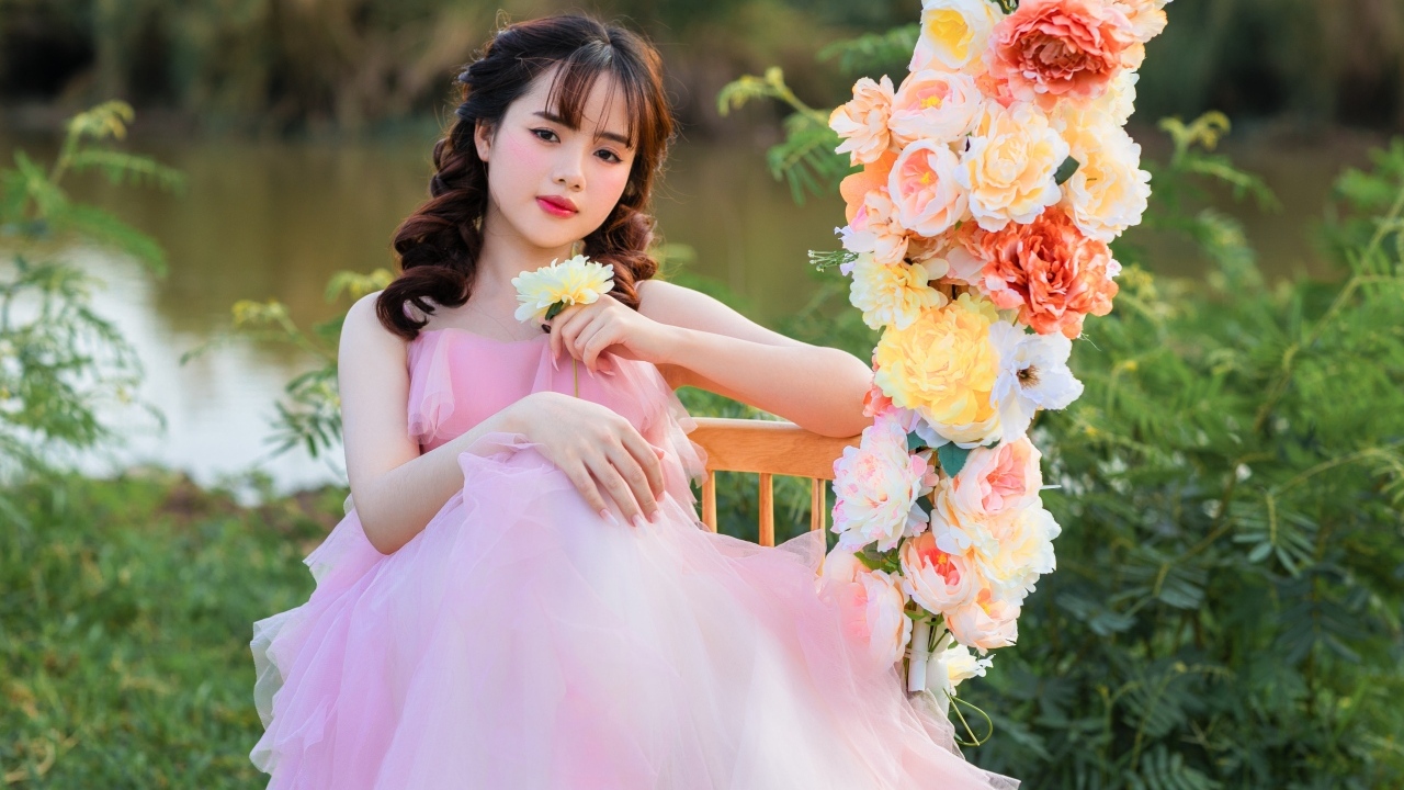 Красивая девушка азиатка в розовом платье с цветами