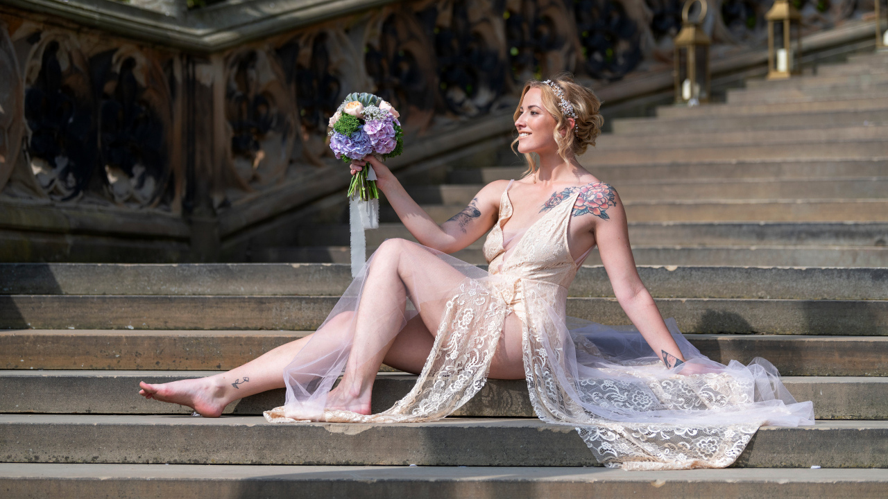 Красивая девушка невеста в платье с букетом на ступеньках