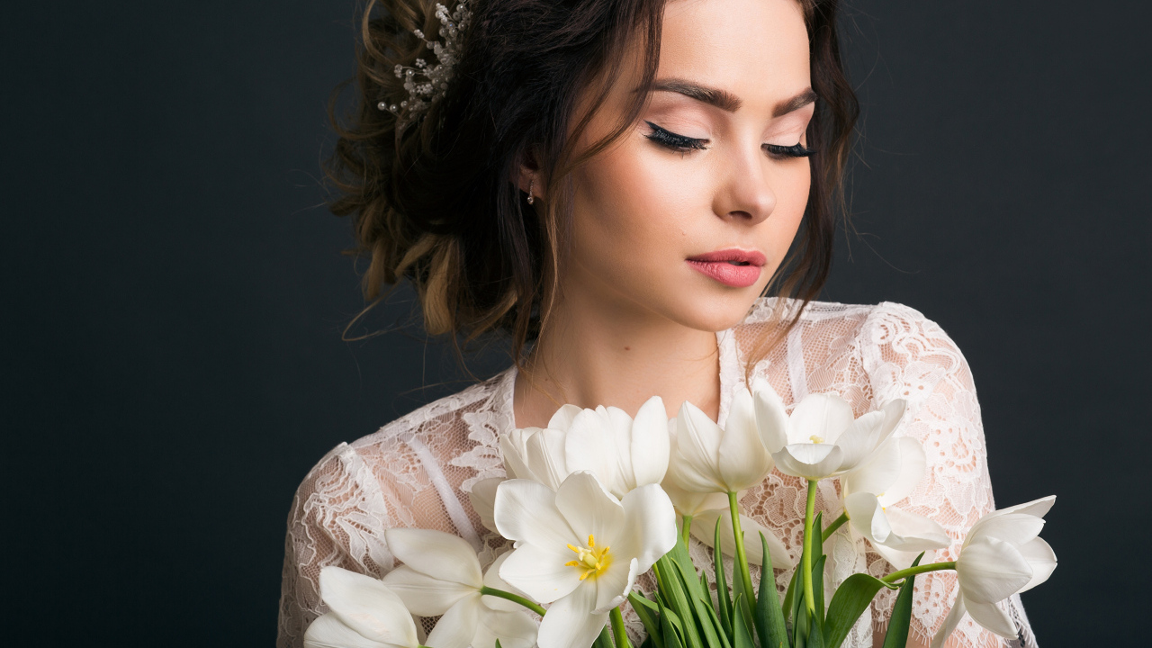 Красивая девушка с букетом белых тюльпанов на сером фоне