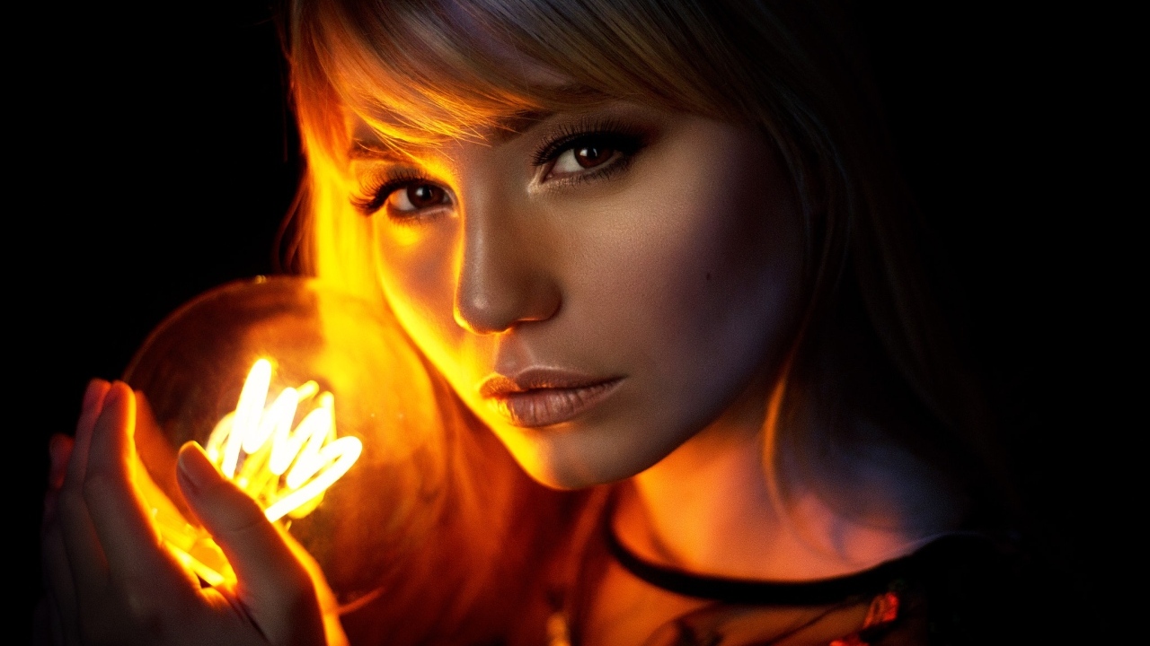 Кареглазая девушка с лампочкой в руках