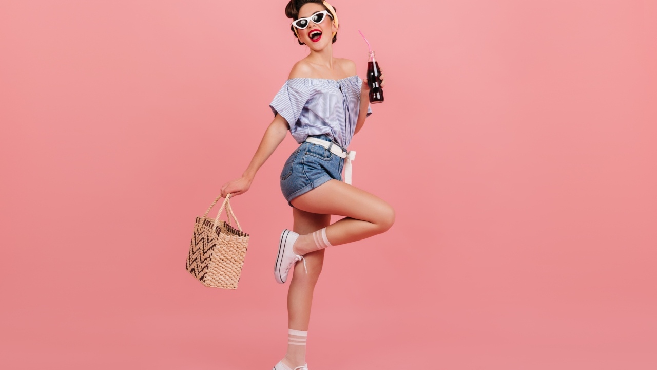 Веселая девушка с сумкой на розовом фоне 