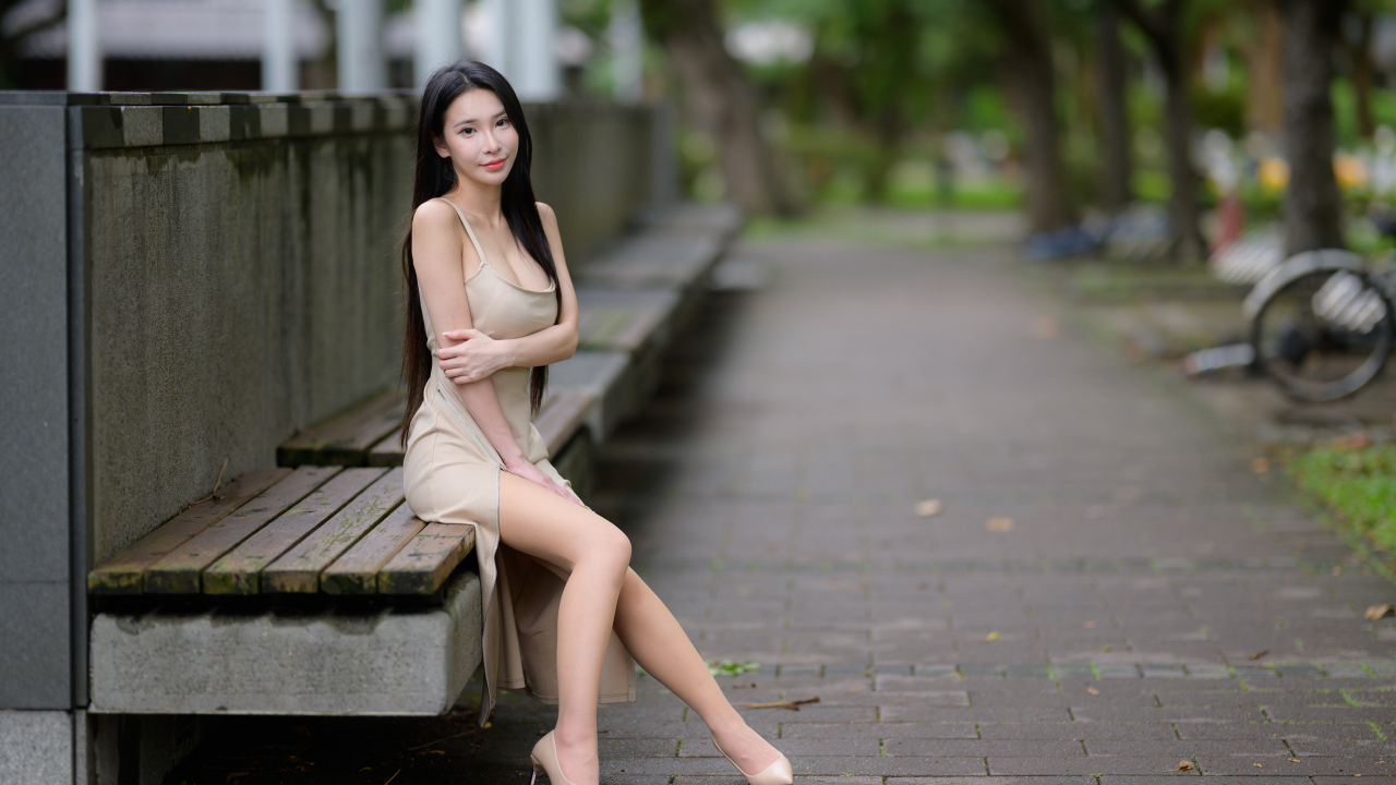 Милая девушка азиатка сидит на лавке